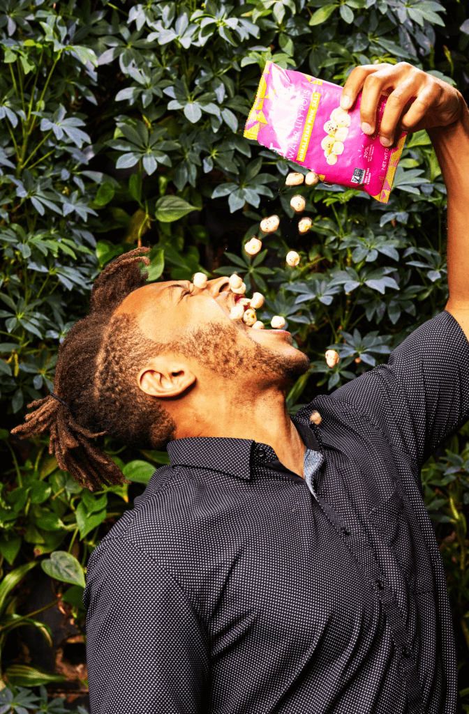 A man enjoying a bag of chips.