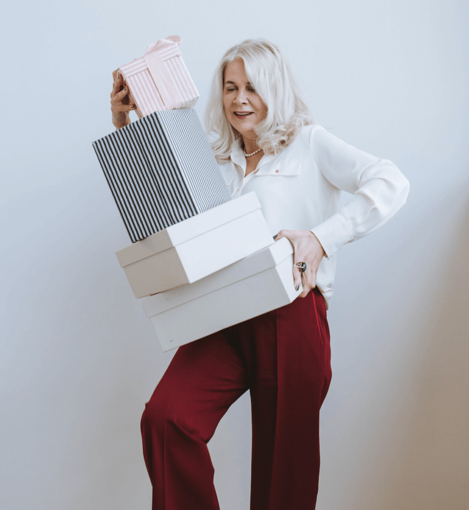 woman with silver hair carrying retirement gift boxes with happiness