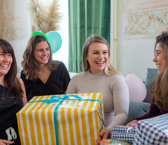 10 Best Gifts For Friends — Under $100 A group of friends unwrapping gifts