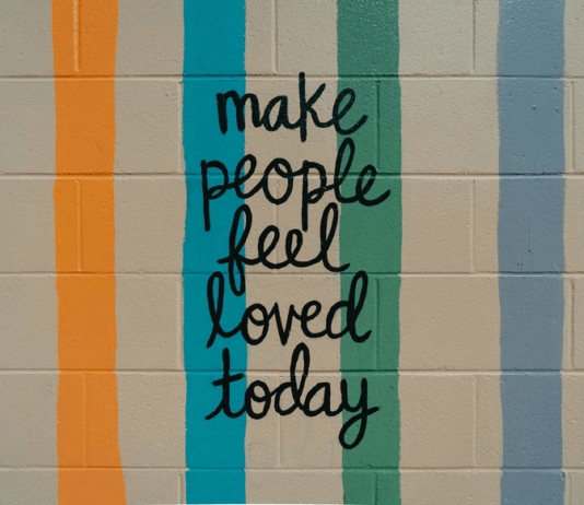 7 Unique and Meaningful Sympathy Gifts for Friends and Loved Ones A cinderblock wall painted with cheerful colors and a handwritten message that says "make people feel loved today"