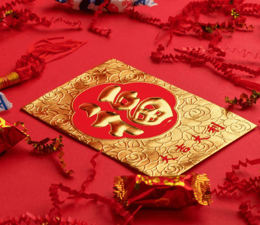 It’s the Year of the Tiger: Why Not Start it with a Roar? A red and gold card on a table decorated in red for Lunar New Year