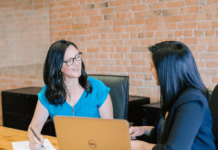 5 New Corporate Gifting Trends in 2024 Two women in an office having a pleasant conversation at work.