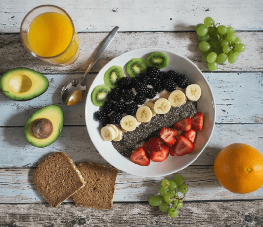 6 Opportunities To Enjoy Healthy Snacks This Summer A spread of healthy food on a table with a full glass of orange juice.