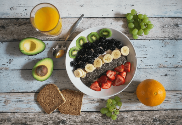 A spread of healthy food on a table with a full glass of orange juice.