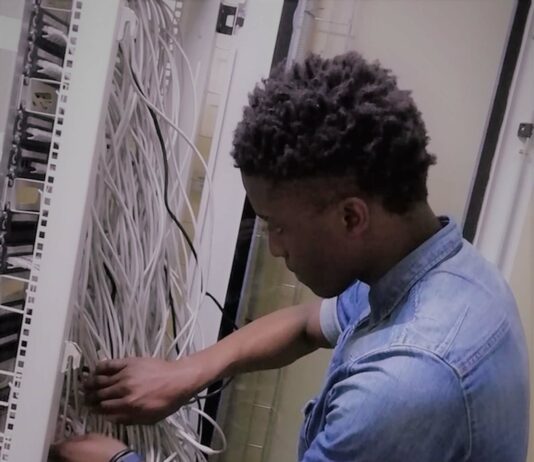 Celebrate Your IT Professionals with these 6 Gift Ideas A young man working in a server room with lots of wires.