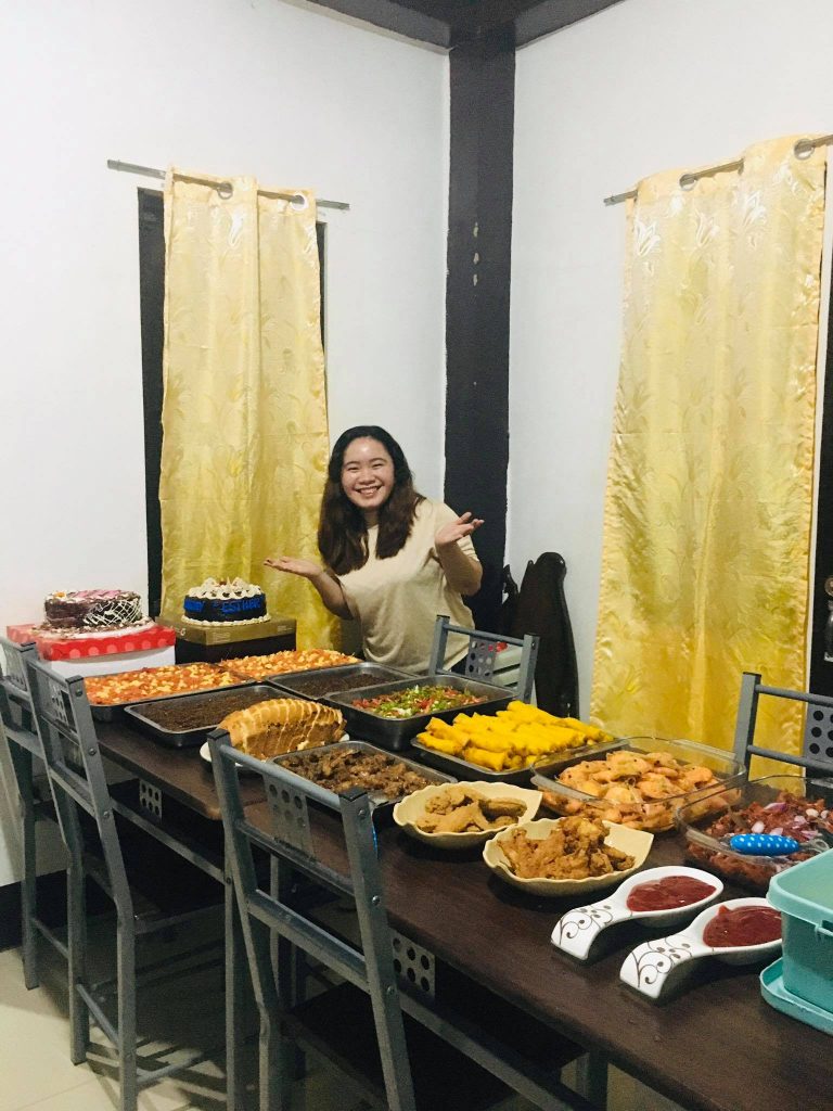 Maria poses with a huge array of traditional Filipino Birthday foods and treats.